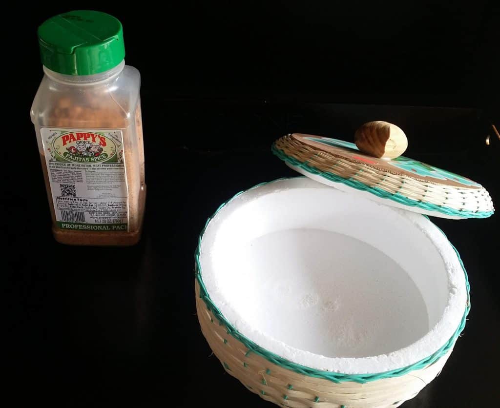 Fajita seasoning and the tortilla warmer set up next to the griddle